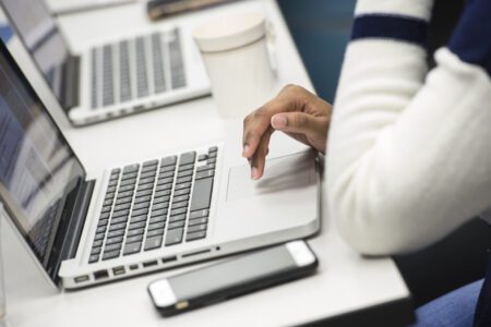 Person typing on laptop keyboard