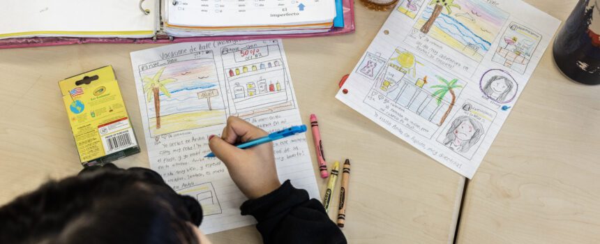 Bird's-eye view of a young student writing on a worksheet