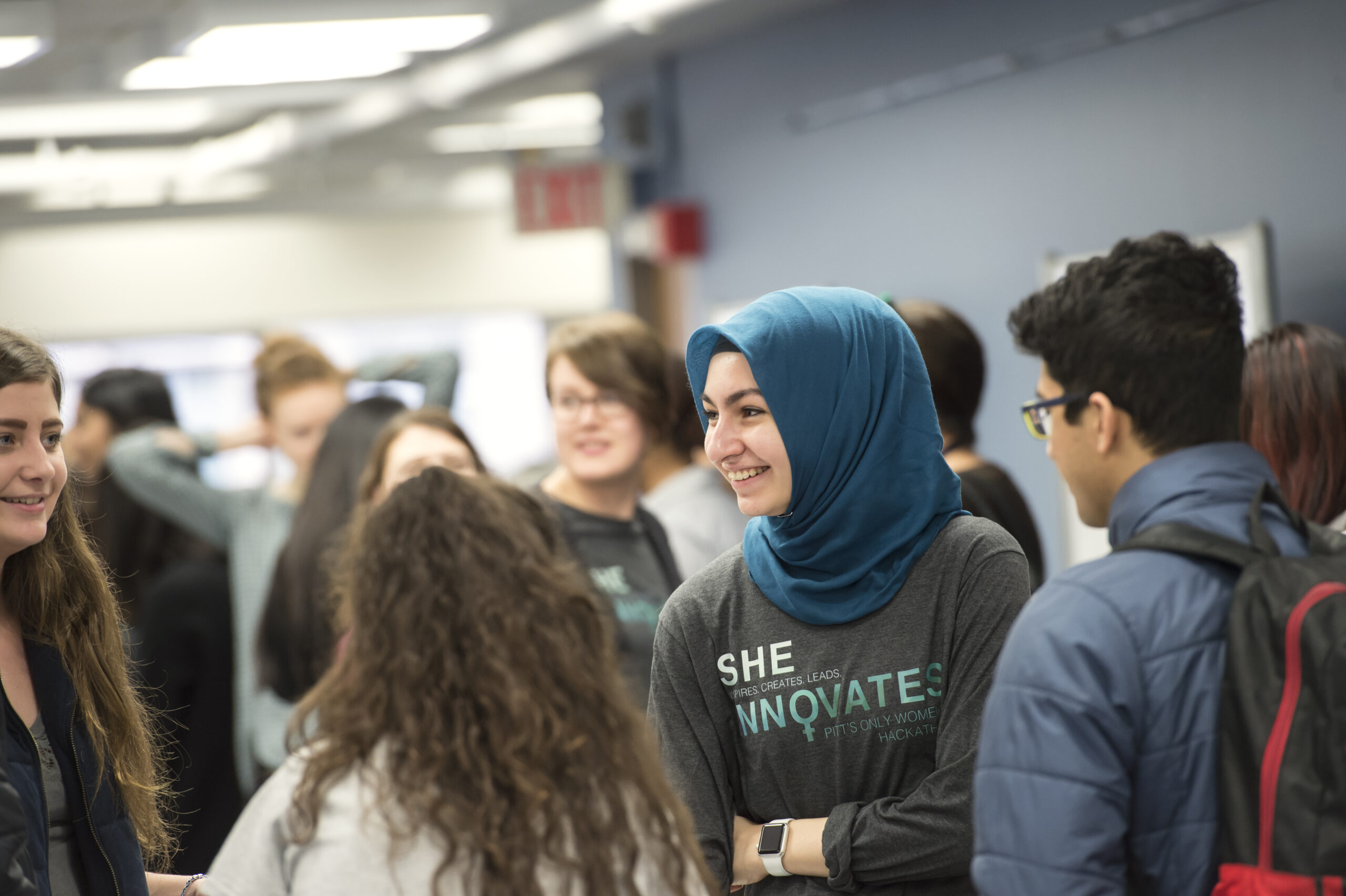 Student smiling while talking with a group of other students
