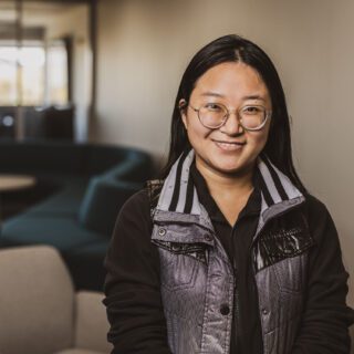 Liying Chen, a female student, standing in the student welcome center