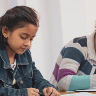 Two young students writing on worksheets