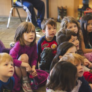 Group of primary school students sitting on a classroom floor