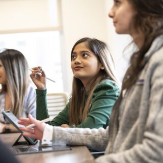 A PhD student learning in the classroom with her peers