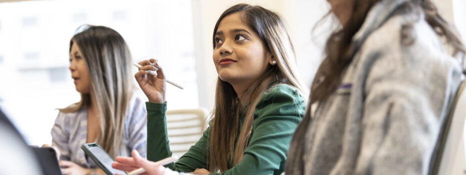 A PhD student learning in the classroom with her peers