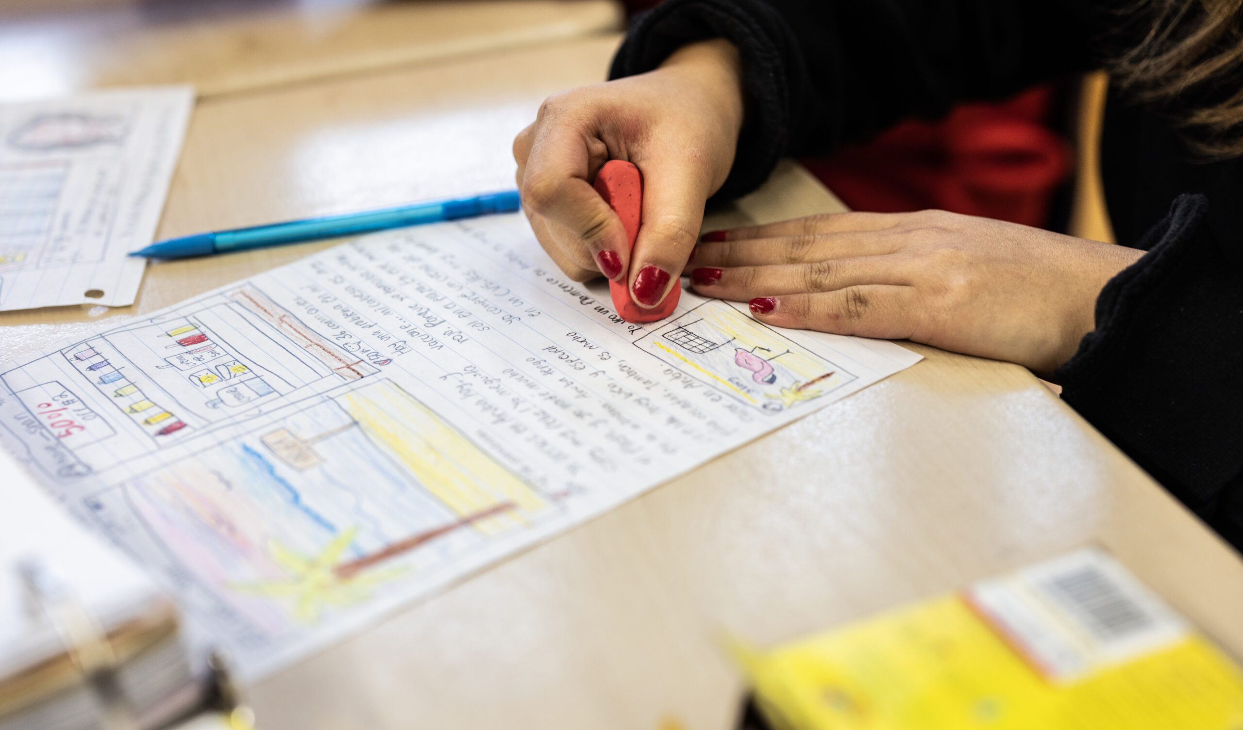 Hands writing on a test in school