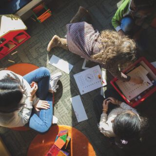 Overhead shot looking down on a student sitting with a group of three young students