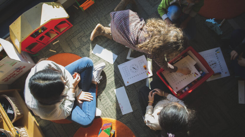 Overhead shot looking down on a student sitting with a group of three young students