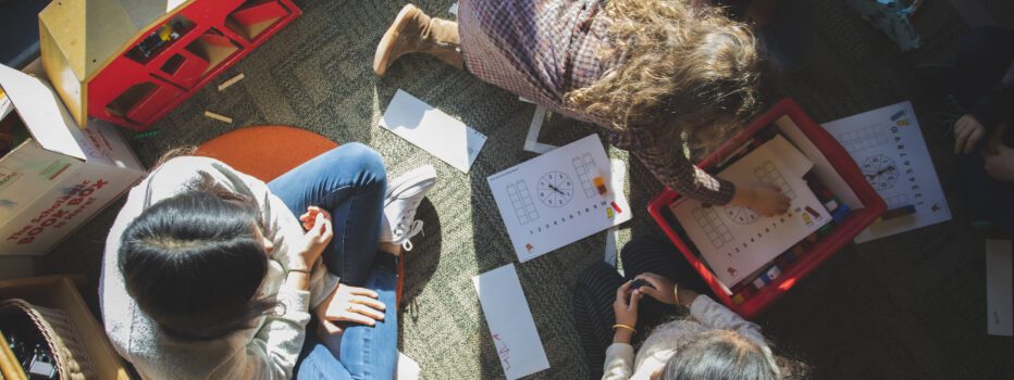 Overhead shot looking down on a student sitting with a group of three young students