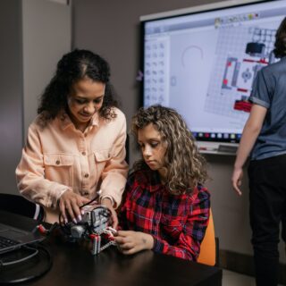 Teacher helping a student with a robotics project