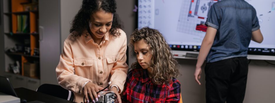 Teacher helping a student with a robotics project