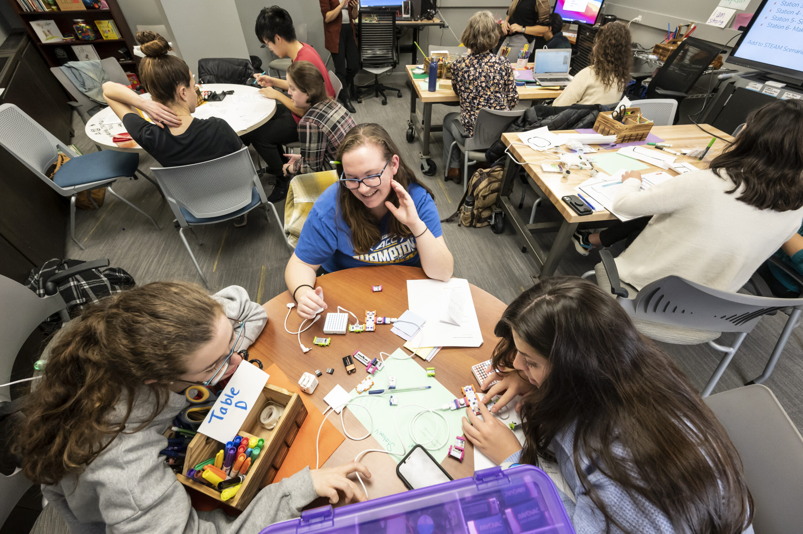 Three students work on a circuitry project in a makerspace classroom