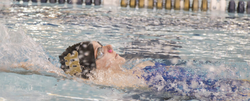 Swimmer doing a backstroke in a pool