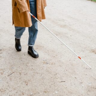 Blind person crossing street with the aid of a walking stick