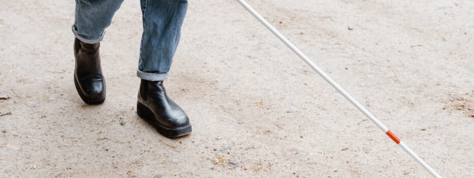 Blind person crossing street with the aid of a walking stick