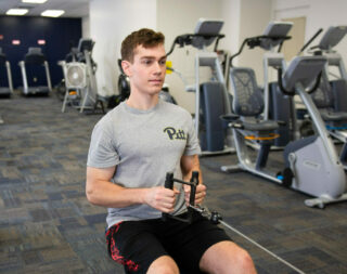 Person does a seated row in a fitness center