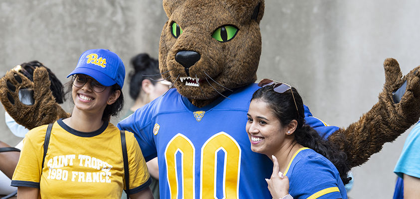 Pitt's mascot, Roc, poses with two students