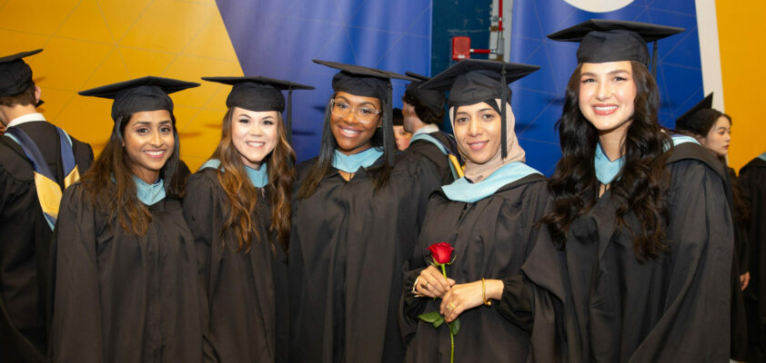 Five students in graduation regalia