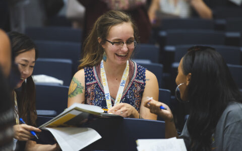 Girl talking to others and smiling at orientation