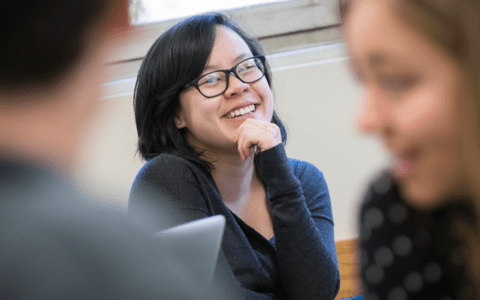 PhD program student smiling in classroom