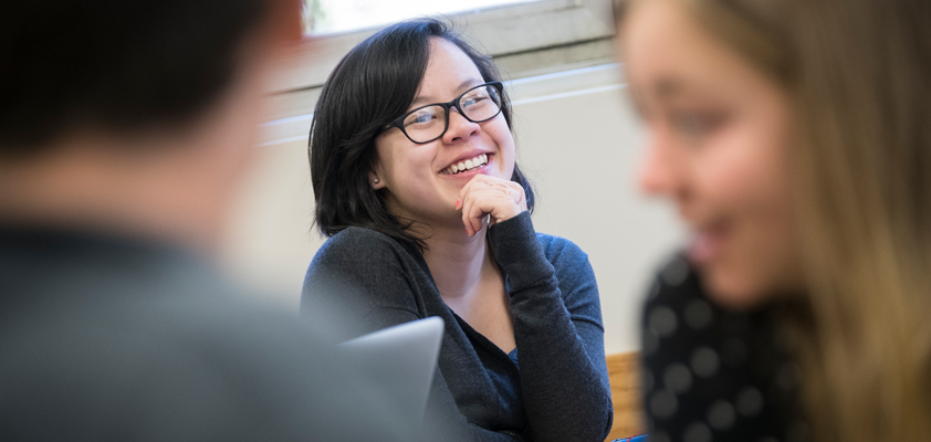 PhD program student smiling in classroom