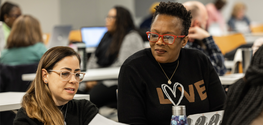 Two EdD students in the classroom talking