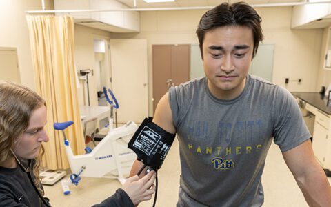 Two students conduct a stress test on a treadmill