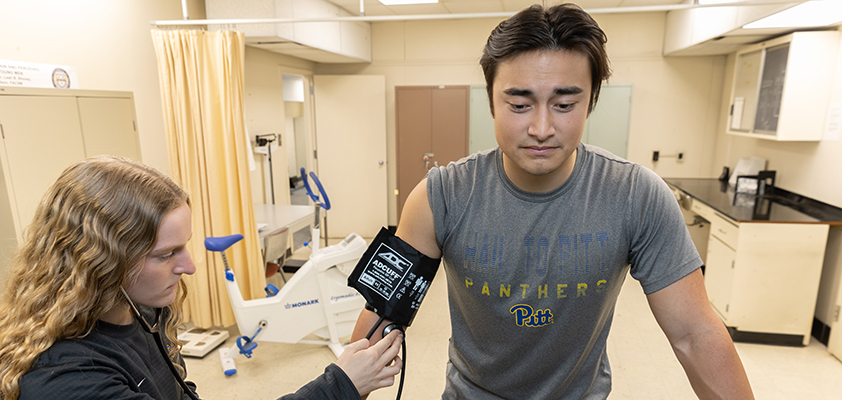 Two students conduct a stress test on a treadmill