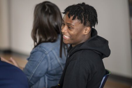 Justice Scholar student laughing while hanging out with his teachers