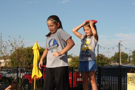 Two kids playing sports outside in a Pitt youth program