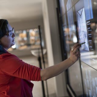 Student using an interactive touch-screen wall in Hillman Library