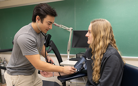 Student takes the blood pressure of another student