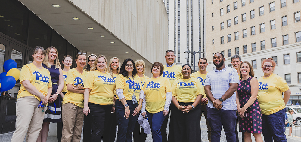 Group of School of Education staff in yellow Pitt t-shirts