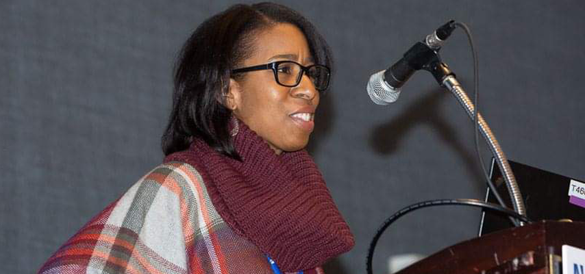 Eboni speaking at a podium