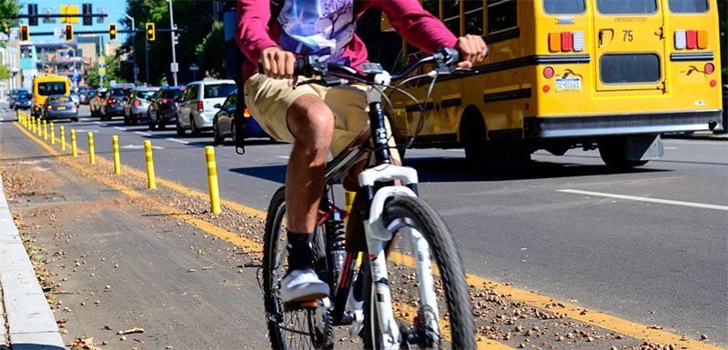 A person riding a bike with a school bus in the background