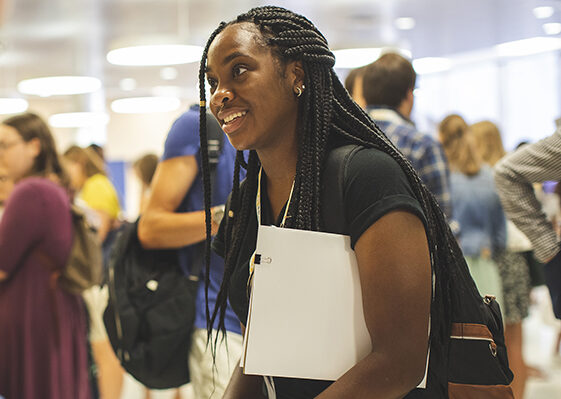 Student holding a folder in a crowd