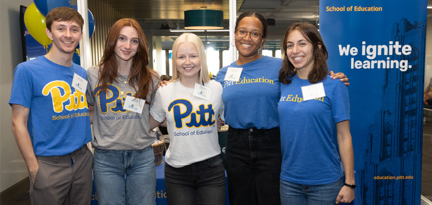 A group of students posing together for homecoming in front of the school's welcome center