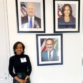 Dean Zamani-Gallaher standing by signs of top officials