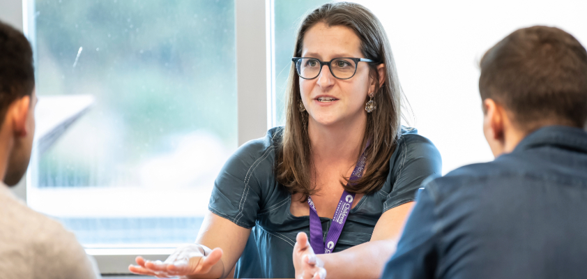 A person talking to two other people